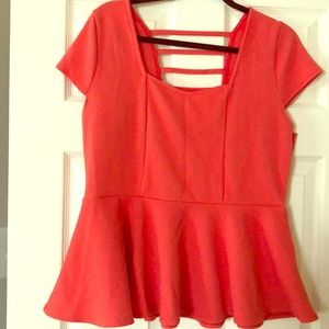 Coral peplum blouse — sweetheart cut.